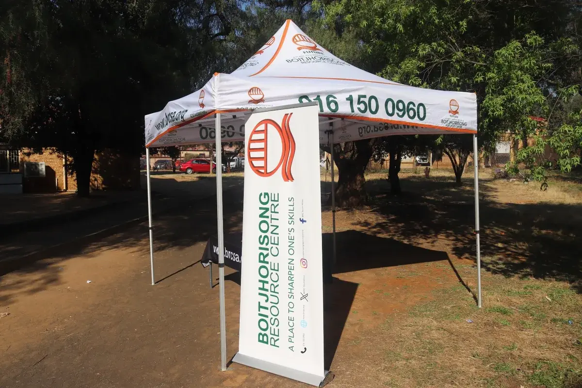 A branded Boitjhorisong Resource Centre gazebo and banner set up on the school grounds